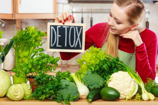 Woman having green diet vegetables, detox sign